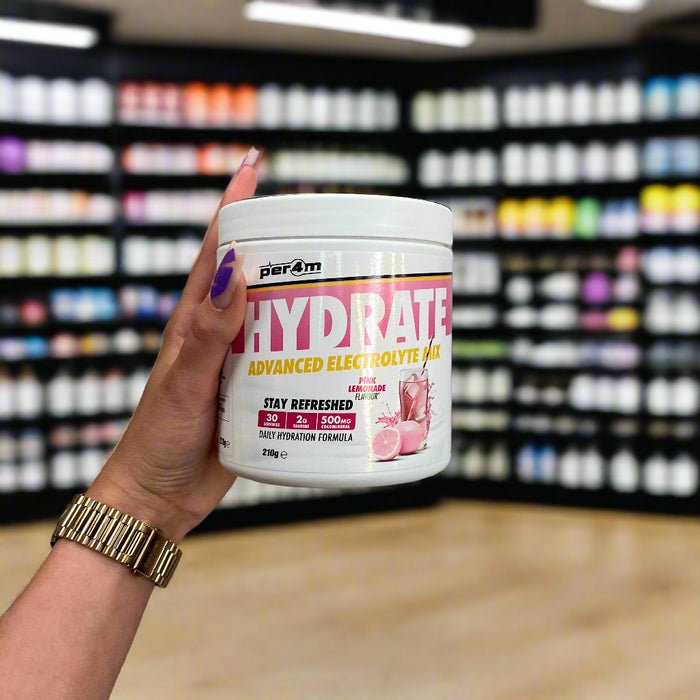 Close-up of (Per4m Hydration Electrolyte Mix 30 Servings) held up inside My Supplement Shop, clearly showing the front label in a Sports Nutrition setting.